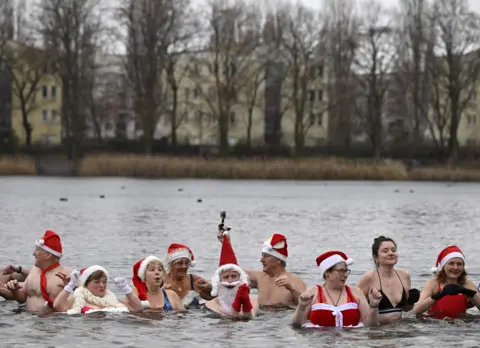 AFP Members of a swimming club take their traditional Christmas bath at the Orankesee lake in Berlin