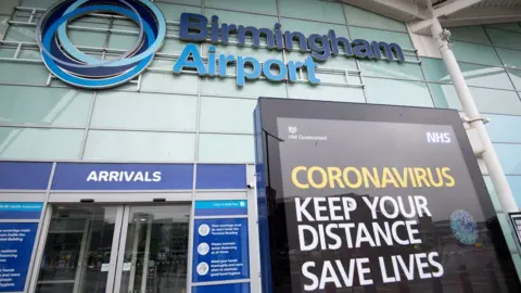 PA Media A coronavirus sign outside Birmingham airport