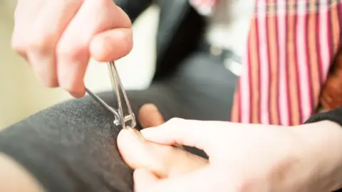 Getty Images A man clipping toenails