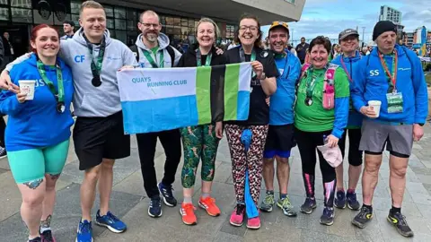 Salford Quays Running Club Symons, far right, and The Quays Running Club post race in 2024