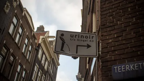 Getty Images A sign pointing to a men's urinal in Amsterdam