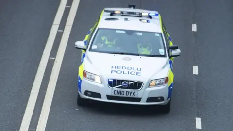 Gwent Police A police car driving along the road