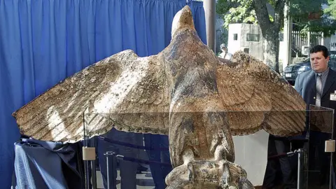 A security guard looks at the bronze eagle recovered from the stern of the WW2 German battleship Graf Spee, scuttled 17 December 1939 off the coast of the Uruguayan capital, on display in Montevideo 13 February, 2006.