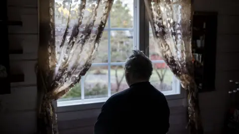 Getty Images Lonely person staring out window