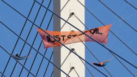 PA Media A Just Stop Oil banner hangs on the QEII Bridge between Kent and Essex