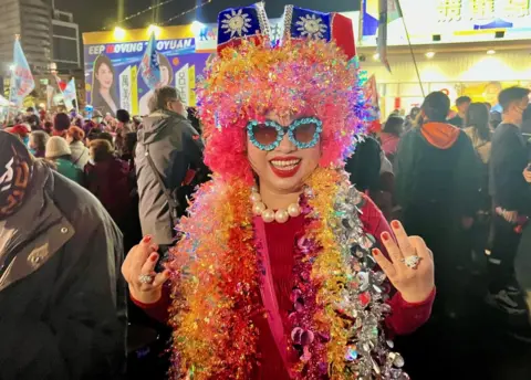 A woman dressed in tinsel and Christmas lights at the KMT rally