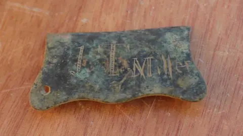 Oxford Archaeology East Ltd A buckle plate with the name J.T Miller scored into it