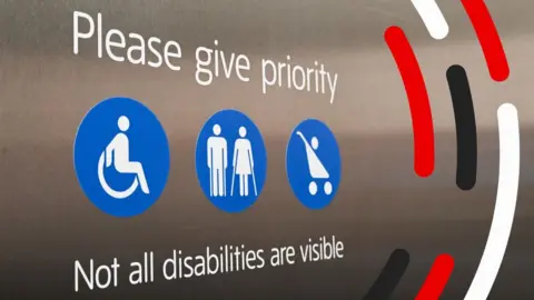A sign that says please give priority, not all disabilities are visible