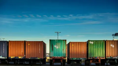 Getty Images line of trucks carrying shipping containers