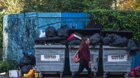 Getty Images Rubbish gathers at a bin area in Glasgow
