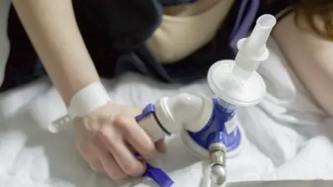 Getty Images A woman holding gas and air pain relief