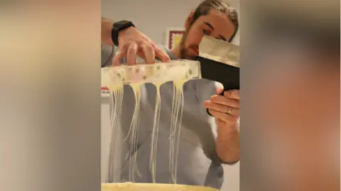 El chocolatero John Tordoff trabajando en un lote de chocolate a partir de un molde.