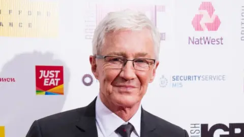 Getty Images Paul O'Grady smiling while wearing a suit at an event