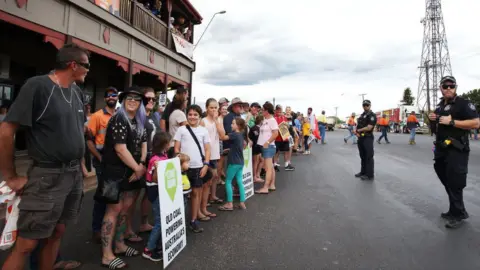 Getty Images Demonstrators hold placards saying "start Adani - Queensland coal powering Australia's economy"