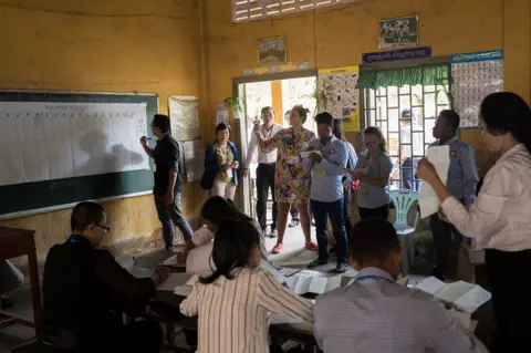 Thomas Cristofoletti / Ruom People watch as calculations are made on a black board