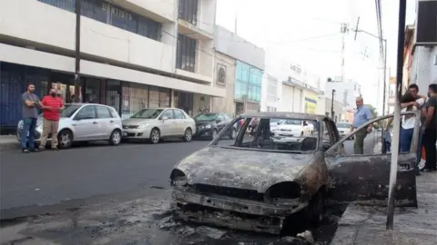 EPA A view of a street after alleged members of criminal gangs set fire to vehicles and blocked roads in the city of Celaya, Guanajuato state, Mexico, 20 June 2020.