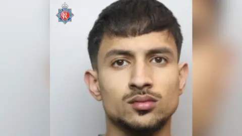 A man in a mugshot with black hair.