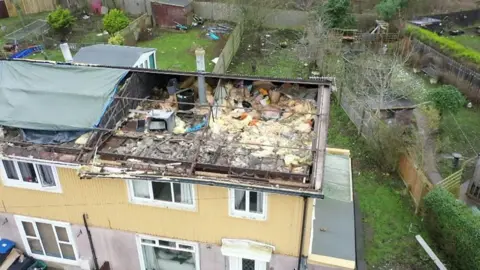 the wrecked roofs of the houses