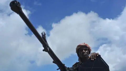 Getty Images Somali soldier holds a machine gun at Sanguni military base, where an US soldier was killed in a mortar attack on 8 June 2018