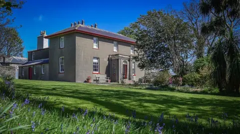 MANX SCENES A two-storey Victorian building with a large green lawn in front of it.