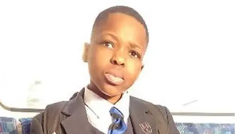 Daniel Anjorin pictured sitting on a bus wearing school uniform