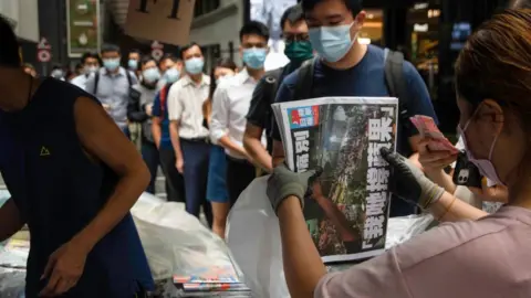 Getty Images People queue to buy the last edition of Apple Daily