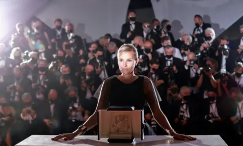 Sarah Meyssonnier / Reuters Director Julia Ducournau poses after winning the Palme d'Or award for the film Titane, in Cannes, France, on 17 July 2021