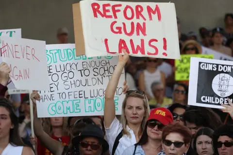 Joe Raedle A woman carries a sign reading "reform gun laws", at the rally in Fort Lauderdale