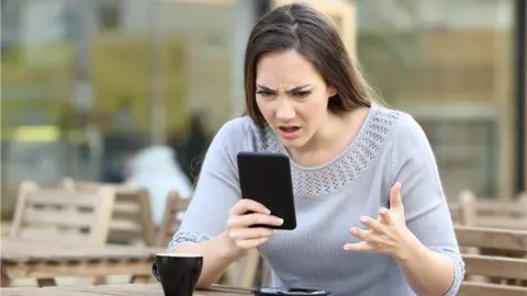 Getty Images Cross customer holding phone