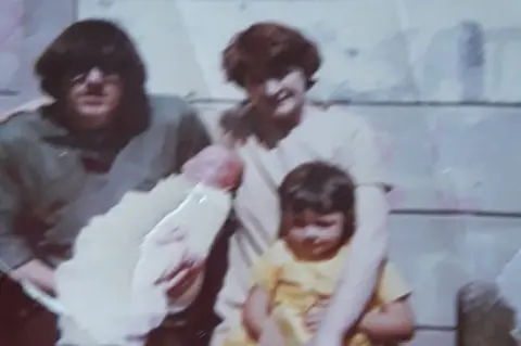 Family photo Joan Connolly with her adult son, her young daughter and her first grandchild