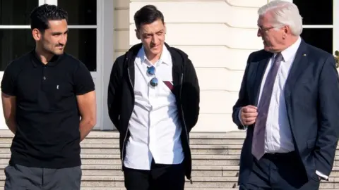 German presidency via EPA Ilkay Gündogan, Mesut Özil and Frank-Walter Steinmeier outside the Bellevue palace in Berlin 19 May 2018