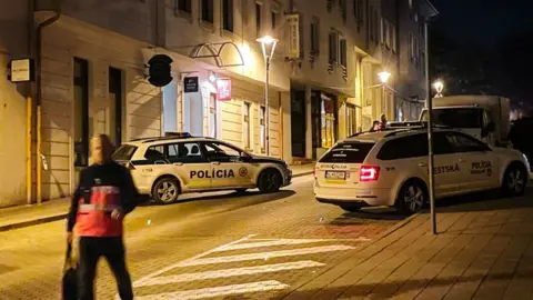 Getty Images Police cars and officers attend the scene on a Bratislava street following a shooting outside an LGBT bar