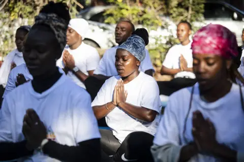 Kim Ludbrook/EPA People practice yoga in the early morning at a venue in Johannesburg on 21 June.