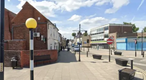 Google An empty street which is partly pedestrianised with buildings on either side.