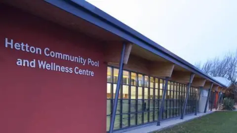 Hetton Community Pool and Wellness Centre. It is a red building with a lot of windows. 