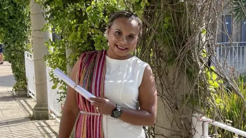 Lisa Jeronimo A woman holding a degree scroll