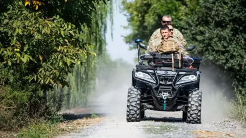 AFP Romanian soldiers ride an ATV down a street in the village of Plauru
