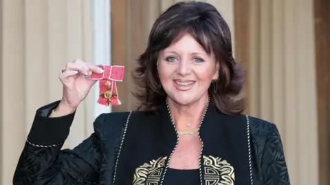 PA Media Margaret Miles-Bramwell holding an OBE she received at Buckingham Palace in London for services to Healthcare and to charity.