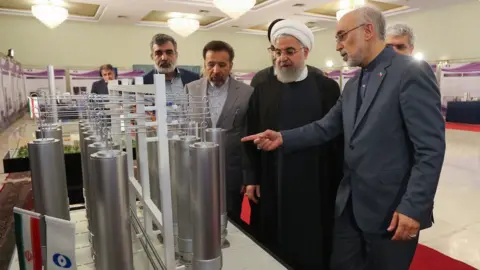 EPA A handout photo showing Iranian President Hassan Rouhani (C) and the head of the Atomic Energy Organisation of Iran, Ali Akbar Salehi (R), inspecting nuclear technology in Tehran, Iran (9 April 2019)