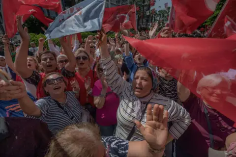 CAN EROK/AFP Supporters of Turkey's Republican People's Party (CHP) Chairman and Presidential candidate Kemal Kilicdaroglu wave during a campaign meeting at the municipality theatre in Adana, on May 25, 2023, ahead of the May 28 presidential runoff vote.