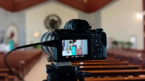 Getty Images Camera records a church service