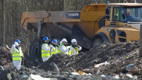 Paperpix.uk Teams searching the landfill site