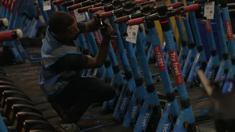 BBC Man fixing e-scooters at Dott depot