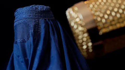 A woman in a burka looks away from the camera