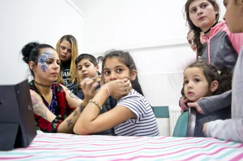 Laura Balogova face painting at Roma family celebration