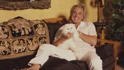 Getty Images Peter Stringfellow with his pet cat, circa 1990