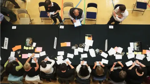 PA Election staff count ballot papers for the General Election, at Kendal Leisure Centre in Kendal.