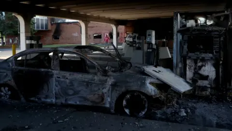 Reuters A burnt vehicle in the aftermath of protests in Minneapolis, Minnesota, 30 May 2020