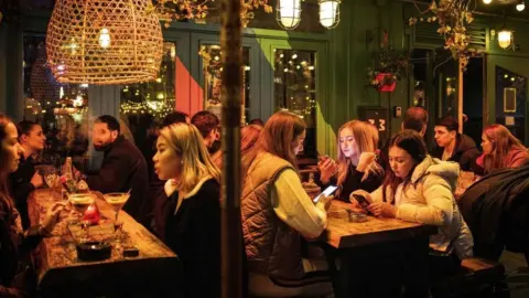 AFP via Getty Images People in a bar in Amsterdam