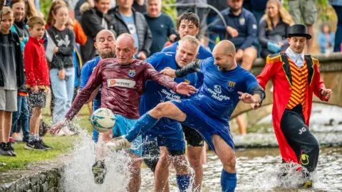 PA Media Bourton-on-the-Water football in the river